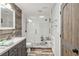 Modern bathroom features wood-look accent wall and tile shower with a frameless glass door at 9939 Triple Crown Cir, Orlando, FL 32825