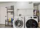 Spacious laundry room with newer washer and dryer, hanging rack, and additional storage at 9939 Triple Crown Cir, Orlando, FL 32825