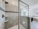 Modern bathroom featuring tile shower, glass door, and double vanity at 10018 Halesia Woods Dr, Orlando, FL 32832