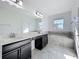 Modern bathroom featuring double sinks, black cabinetry, and a soaking tub, creating a spa-like retreat at 10018 Halesia Woods Dr, Orlando, FL 32832
