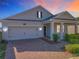 Beautiful exterior showcasing a well-maintained lawn, brick driveway, and covered porch with classic columns at 10018 Halesia Woods Dr, Orlando, FL 32832