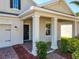 Inviting covered front porch with brick flooring and stately white columns at 10018 Halesia Woods Dr, Orlando, FL 32832