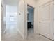 Hallway leads to view of the bathroom and into the spacious and modern living area at 10018 Halesia Woods Dr, Orlando, FL 32832