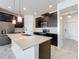Modern kitchen with large quartz island, pendant lights, stainless steel appliances, and dark wood cabinets at 10018 Halesia Woods Dr, Orlando, FL 32832