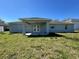 Backyard view featuring a covered porch and green grass at 110 Evergreen Dr, Auburndale, FL 33823