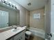 Bathroom features vanity with mirror, shower-tub combo with tiled backsplash and exhaust fan at 110 Evergreen Dr, Auburndale, FL 33823