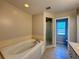 Bright bathroom featuring a large soaking tub and glass enclosed shower at 110 Evergreen Dr, Auburndale, FL 33823