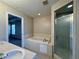 Bathroom featuring double sinks, a tub, and a separate glass shower at 110 Evergreen Dr, Auburndale, FL 33823