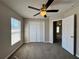 Cozy bedroom features carpet flooring, a ceiling fan, and ample natural light through the window at 110 Evergreen Dr, Auburndale, FL 33823