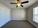 Well-lit bedroom with ceiling fan, carpet flooring and closet with bifold doors at 110 Evergreen Dr, Auburndale, FL 33823