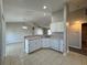 Bright open kitchen featuring white cabinets, a breakfast bar, and tile floors leading to living room at 110 Evergreen Dr, Auburndale, FL 33823