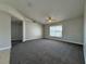Spacious carpeted living room with a ceiling fan and large window offering natural light at 110 Evergreen Dr, Auburndale, FL 33823