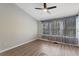 A bright bedroom with new flooring, a modern ceiling fan, and large windows covered with decorative black-out curtains at 1178 Vineland Pl, Lake Mary, FL 32746