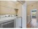 A functional laundry room featuring a modern washer and dryer set, with wire shelving for convenient storage at 1178 Vineland Pl, Lake Mary, FL 32746