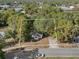 Charming home nestled among mature trees, featuring a long driveway and a car parked on the street at 1208 Bonaire Dr, Leesburg, FL 34748