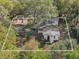 Aerial view of a home surrounded by mature trees, a covered patio, and a long driveway at 1208 Bonaire Dr, Leesburg, FL 34748