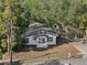 Charming home nestled among mature trees featuring a welcoming entrance and a spacious driveway at 1208 Bonaire Dr, Leesburg, FL 34748
