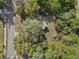 Aerial view of the property showing lush, mature trees and other buildings nearby at 1208 Bonaire Dr, Leesburg, FL 34748