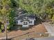 Charming home nestled among mature trees featuring a welcoming entrance and a spacious driveway at 1208 Bonaire Dr, Leesburg, FL 34748