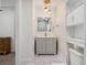 Bright bathroom with marble floors, gray vanity, and white-trimmed mirror and overhead lighting at 1208 Bonaire Dr, Leesburg, FL 34748