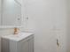 Bathroom sink and vanity with gray cabinets, a white countertop, and gold fixtures at 1208 Bonaire Dr, Leesburg, FL 34748