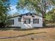 A charming white house with an American flag, dark shutters, and a front porch at 1208 Bonaire Dr, Leesburg, FL 34748