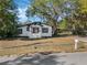 Charming single-story home with a well-maintained lawn, carport, and mature trees at 1208 Bonaire Dr, Leesburg, FL 34748