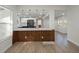 Open concept kitchen with quartz countertops, stainless appliances, and eat-in bar area extending to dining room at 1208 Bonaire Dr, Leesburg, FL 34748