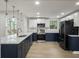 Modern kitchen with quartz countertops, navy and white cabinets, stainless steel appliances, and stylish light fixtures at 1208 Bonaire Dr, Leesburg, FL 34748