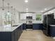 Modern kitchen with quartz countertops, navy and white cabinets, stainless steel appliances, and stylish light fixtures at 1208 Bonaire Dr, Leesburg, FL 34748