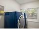 Laundry room with newer, dark blue washer and dryer near a window at 1208 Bonaire Dr, Leesburg, FL 34748