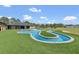 Lush backyard featuring a uniquely designed blue inground pool and well-maintained turf grass area at 12323 Sweet Hill Rd, Polk City, FL 33868