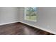 A well-lit bedroom featuring hard wood floors, a large window and gray walls at 12323 Sweet Hill Rd, Polk City, FL 33868