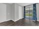 A well-lit bedroom showcasing dark floors, blue curtains and a sliding glass door at 12323 Sweet Hill Rd, Polk City, FL 33868