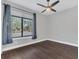 Bright bedroom featuring dark floors, ceiling fan, a large window, and a view of the outdoors at 12323 Sweet Hill Rd, Polk City, FL 33868