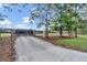 Gated entrance leading to a modern home with a long driveway and lush landscaping at 12323 Sweet Hill Rd, Polk City, FL 33868