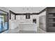 Modern kitchen with white cabinetry, stainless steel appliances, an island, and sleek black accents at 12323 Sweet Hill Rd, Polk City, FL 33868