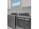 Modern laundry room featuring stainless steel washer and dryer with white cabinets at 12323 Sweet Hill Rd, Polk City, FL 33868
