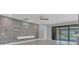 Modern living room featuring a unique stone wall design, slider doors, and a ceiling fan at 12323 Sweet Hill Rd, Polk City, FL 33868