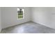 Cozy bedroom featuring gray tile flooring and a window overlooking the exterior surroundings at 13687 Sw 33Rd Cir, Ocala, FL 34473