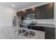 Close-up showcasing the kitchen's granite countertops, dark cabinetry, and stainless steel appliances at 13687 Sw 33Rd Cir, Ocala, FL 34473