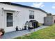 Backyard patio with gray tile, white vinyl wall, outdoor grill, patio chair, and storage shed at 1401 W Highway 50 # 45, Clermont, FL 34711