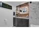 Bathroom vanity features marble countertop, rustic wood backsplash, and a decorative mirror with tile shower at 1401 W Highway 50 # 45, Clermont, FL 34711