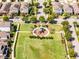 An aerial view of a neighborhood park with a playground and well-maintained landscaping and colorful houses at 15580 Blackbead St, Winter Garden, FL 34787