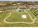 Aerial shot of a vast community park with green space, walking trails, and a playground, perfect for outdoor activities at 15580 Blackbead St, Winter Garden, FL 34787