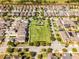An aerial view showcasing a community park nestled among neatly arranged homes in a well-planned neighborhood with greenery at 15580 Blackbead St, Winter Garden, FL 34787