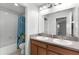 Bathroom with double sinks, a large mirror, and a tub/shower combo with a colorful curtain at 15580 Blackbead St, Winter Garden, FL 34787