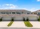 Modern townhome exterior showing garages and landscaped driveways under a blue sky at 15580 Blackbead St, Winter Garden, FL 34787