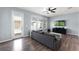 Living room with hardwood floors, large windows, and a comfortable gray sofa; ideal for relaxation at 15580 Blackbead St, Winter Garden, FL 34787