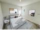 Bright bedroom featuring a gray bed frame, white bedding, and neutral abstract art at 16947 Sw 22Nd Terrace Rd, Ocala, FL 34473